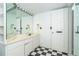 Bathroom featuring a large mirror with vanity lights, cabinets, and classic black and white checkerboard flooring at 20 Palm Dr, Placida, FL 33946