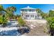 Charming coastal home exterior surrounded by lush tropical landscape, offering a tranquil and private setting at 20 Palm Dr, Placida, FL 33946