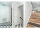 Hallway with checkerboard floors leads to stairs with wood treads and white risers, plus an open doorway at 20 Palm Dr, Placida, FL 33946