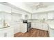 Well-appointed kitchen featuring white cabinets, stainless steel appliances, modern fixtures, and hardwood flooring at 20 Palm Dr, Placida, FL 33946