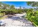 Backyard view leading to a waterfront area with a wooden dock, surrounded by lush greenery at 20 Palm Dr, Placida, FL 33946