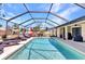 The screened-in pool area boasts a sunny deck with multiple lounge chairs and outdoor dining at 23148 Corvin Ave, Port Charlotte, FL 33954