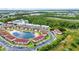 Aerial view of condo buildings surrounding a pond with a fountain and lush green trees at 25100 Sandhill Blvd # R104, Punta Gorda, FL 33983