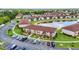 Aerial view of condo buildings with ample parking surrounding a pond with a fountain at 25100 Sandhill Blvd # R104, Punta Gorda, FL 33983