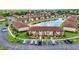 Aerial view of condo buildings surrounding a pond with a fountain and ample parking at 25100 Sandhill Blvd # R104, Punta Gorda, FL 33983