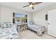 Cozy bedroom featuring two twin beds, a desk, and a ceiling fan for added comfort at 25100 Sandhill Blvd # R104, Punta Gorda, FL 33983