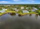Aerial view of homes on a lake with landscaped yards and mature trees at 3 Bermuda Cir # 49, Englewood, FL 34223