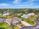 Aerial view of home with manicured lawn, mature trees, and a spacious driveway at 3 Bermuda Cir # 49, Englewood, FL 34223