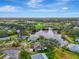 Aerial view of a charming home nestled by a serene lake and a lush green golf course in the distance at 3 Bermuda Cir # 49, Englewood, FL 34223