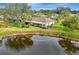 Aerial view of property with backyard pond, screened lanai, and mature landscaping at 3 Bermuda Cir # 49, Englewood, FL 34223