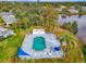 Aerial view of a community pool and lake, surrounded by mature trees at 3 Bermuda Cir # 49, Englewood, FL 34223