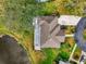 Aerial view of a home with a large landscaped yard next to a pond at 3 Bermuda Cir # 49, Englewood, FL 34223