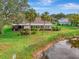 Aerial view of home's lush lawn and screened lanai beside a lake at 3 Bermuda Cir # 49, Englewood, FL 34223