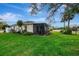 Green backyard with a screened in patio area overlooking the lake at 3 Bermuda Cir # 49, Englewood, FL 34223