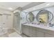 Bathroom with dual sinks, marble counters, and a glass shower door at 3 Bermuda Cir # 49, Englewood, FL 34223