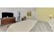 A sun-filled bedroom includes a TV, and neutral-toned bedding on a wood frame at 3 Bermuda Cir # 49, Englewood, FL 34223