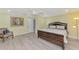 Comfortable bedroom with wood-look floors, a stylish chair, and a serene painting at 3 Bermuda Cir # 49, Englewood, FL 34223