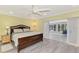 Bright bedroom with a ceiling fan, wood-look floors, and an adjoining sunroom at 3 Bermuda Cir # 49, Englewood, FL 34223