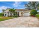 Elegant home showcasing a large driveway, meticulous landscaping, and an attached garage at 3 Bermuda Cir # 49, Englewood, FL 34223