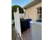 Exterior shows trash cans hidden by white fence along tan house, with air conditioning unit in the foreground at 3 Bermuda Cir # 49, Englewood, FL 34223