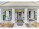 Inviting front porch with classic columns and a cozy seating area, enhancing the home's charm at 3 Bermuda Cir # 49, Englewood, FL 34223