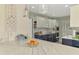 Open kitchen layout with white cabinets, stainless appliances, and stone countertops at 3 Bermuda Cir # 49, Englewood, FL 34223