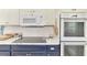 Bright kitchen features modern appliances, tile backsplash, and white and navy custom cabinets at 3 Bermuda Cir # 49, Englewood, FL 34223