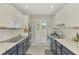 Bright kitchen with white cabinets, tile backsplash, and double ovens at 3 Bermuda Cir # 49, Englewood, FL 34223