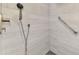 Close-up of tiled shower with handheld sprayer and built-in grab bar at 3 Bermuda Cir # 49, Englewood, FL 34223