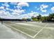 Outdoor tennis court with green surface offers recreational opportunities and a shaded bench at 3 Bermuda Cir # 49, Englewood, FL 34223