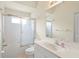 Bright bathroom features a tub with shower and glass doors, and vanity with a large mirror at 3084 Brockton St, North Port, FL 34286