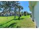 Lush backyard featuring green grass, trees, and a peek at the home at 315 Southland Rd, Venice, FL 34293