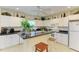 Bright kitchen with white cabinetry, appliances, and a peninsula with stool seating at 315 Southland Rd, Venice, FL 34293