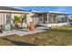 Inviting backyard featuring a patio area with chairs, greenery, and access to a screened-in porch at 3265 Sunrise Trl, Port Charlotte, FL 33952