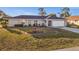Single-story home with neutral exterior, tidy landscaping, and an attached two-car garage at 3265 Sunrise Trl, Port Charlotte, FL 33952