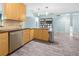 Bright kitchen area with wood cabinetry, stainless steel dishwasher, lots of counter space, and wood-look flooring at 3265 Sunrise Trl, Port Charlotte, FL 33952
