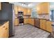 Modern kitchen with stainless steel appliances, wood cabinets, dark countertops and hardwood floors at 3265 Sunrise Trl, Port Charlotte, FL 33952