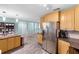 Modern kitchen with stainless steel appliances, wood cabinets, dark countertops, and hardwood floors with a view into the next room at 3265 Sunrise Trl, Port Charlotte, FL 33952