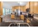 Updated kitchen featuring wood cabinets, stone countertops, and stainless appliances, open to the bright living area at 3265 Sunrise Trl, Port Charlotte, FL 33952