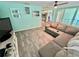 This living room features a large sectional and wood-look tile flooring at 3265 Sunrise Trl, Port Charlotte, FL 33952
