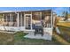 Backyard patio area with a grill, screened-in porch, and outdoor seating, perfect for entertaining and relaxation at 3265 Sunrise Trl, Port Charlotte, FL 33952