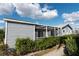 Charming home exterior with gray siding, screened patio, and lush landscaping at 3300 Loveland Blvd # 2103, Punta Gorda, FL 33980