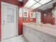 Stylish bathroom with a large vanity, statement mirror, bright lighting and access door to the exterior at 4461 Baroda Ave, North Port, FL 34287