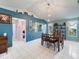 Dining room with blue accent walls, tile floors, dining table and modern pendant lighting at 4461 Baroda Ave, North Port, FL 34287