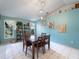 Dining room with light blue walls, tile floors, a dining table and modern pendant lighting at 4461 Baroda Ave, North Port, FL 34287