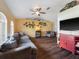 Spacious living room with hardwood floors, a ceiling fan, and a large window for natural light at 4461 Baroda Ave, North Port, FL 34287