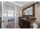 Bathroom featuring a granite countertop, dark wood cabinets, and view of the bedroom that creates a luxurious experience at 5020 Brittany S Dr # 324, St Petersburg, FL 33715
