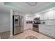 Well-lit kitchen with stainless steel appliances, white cabinetry and patterned tile floors at 5020 Brittany S Dr # 324, St Petersburg, FL 33715