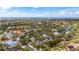 Expansive aerial view of a neighborhood with lush greenery and a scenic ocean backdrop at 5239 Siesta Cove Dr, Sarasota, FL 34242