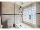 Bright bathroom highlighting the glass shower, pebble floor, and unique glass block window at 5239 Siesta Cove Dr, Sarasota, FL 34242